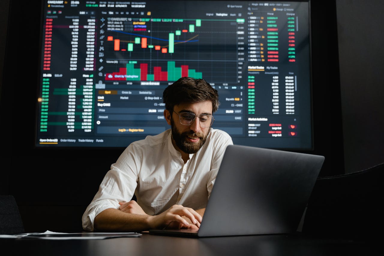 menu-02 Male analyst studies cryptocurrency trends at a workstation with multiple displays showing market data.